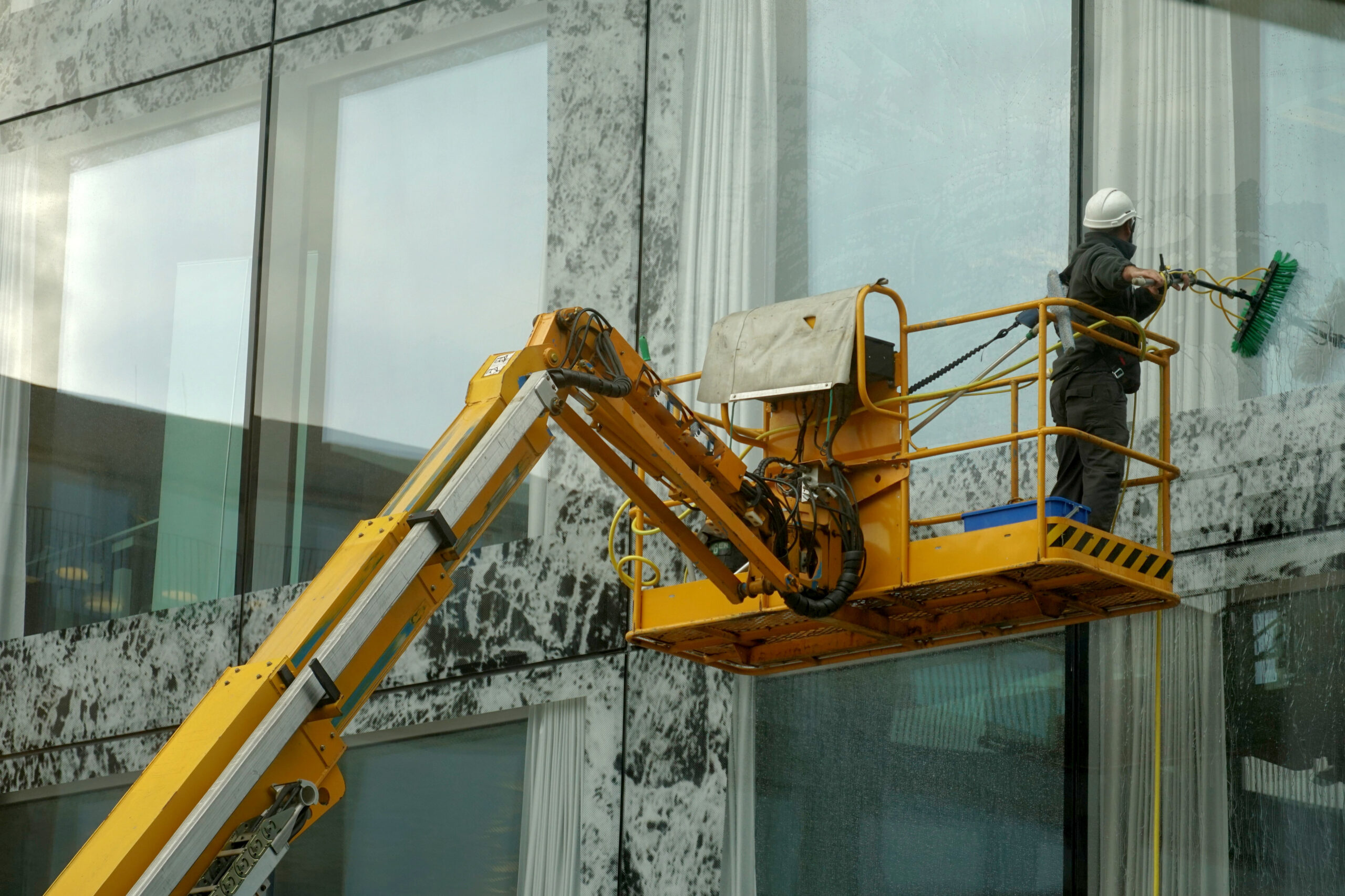 Worker using a boom to clean windows